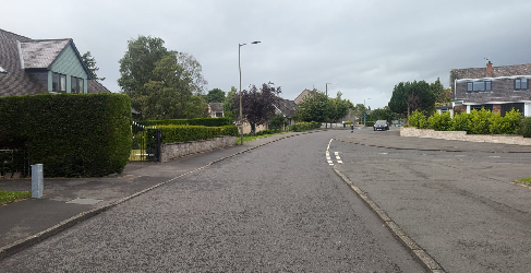 Street view of Laurelhill Place. The road is in the centre and houses are on the left and right. The sky is cloudy.