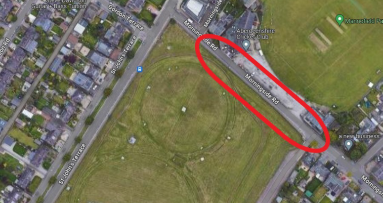 Mannofield Water Treatment Works Extension Period Aerial view of Mannofield Park near Aberdeenshire Cricket Club, highlighted by an oval indicating a specific area on the road and nearby grassy fields surrounded by various local businesses on adjacent streets.