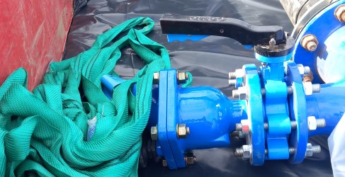 Image of bright blue water main being installed in the ground Image of bright blue water main being installed in the ground