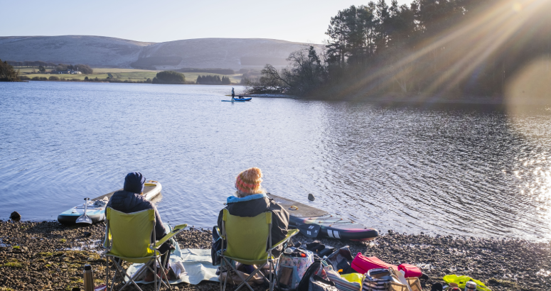 Two people sitting at a reservoir