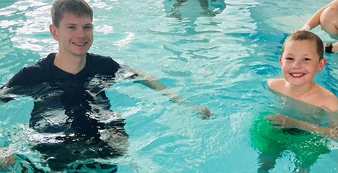 Learn to Swim instructor Nathan McKechnie Learn to Swim instructor Nathan McKechnie in pool teaching youngster Jack
