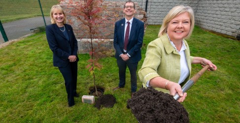 Alex Plant, Deirdre Michie and Provost Judy Whyte Three people smiling as one holds a metal spade covered in mud up to the camera