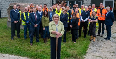 Official opening of Invercannie Water Treatment Works Large group of people smiling in front of concrete building while wearing hi-vis and safety PPE