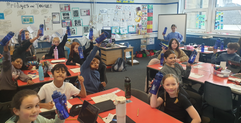 Students with Scottish Water bottles Students raising water bottles in a classroom filled with educational posters