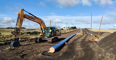 DV4 launch Network pipes laid out on the ground with yellow digger