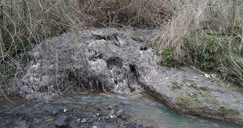 Pollution sewage related debris on a river bank